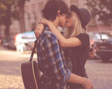 Парень и девушка на улице целуются