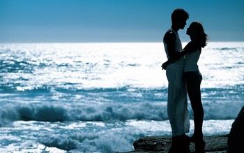 Парень и девушка обнимаются на берегу моря