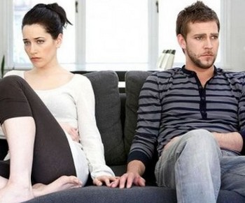 Мужчина и женщина сидят на диване и не смотрят друг на друга